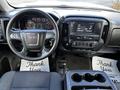 Interior view of a 2017 GMC Sierra 1500 showing the steering wheel dashboard and center console with controls and touchscreen display