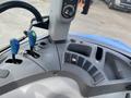 Interior controls of a 2016 New Holland T475 tractor featuring levers buttons and a digital display