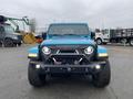 A blue 2020 Jeep Wrangler with distinct front headlights and a rugged build facing the viewer