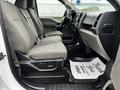 Interior view of a 2017 Ford F-150 showing two front seats with light gray upholstery and a dashboard with controls and features visible