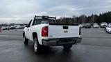 A white 2013 Chevrolet Silverado 1500 truck viewed from the rear with a step-side bed and a high-mounted brake light