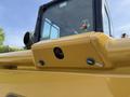 A close-up view of a yellow Caterpillar 306 excavator part showing a camera lens and several bolts