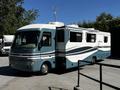 A 2000 Ford Motorhome with a blue and white exterior featuring a large side slide-out and a compact design ideal for camping and travel
