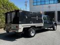 A 2008 Ford F-550 truck with a flatbed featuring black toolboxes and a utility light mounted on top