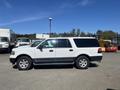 A white 2013 Ford Expedition parked with its side profile visible showcasing four doors and a large body designed for spacious interior and cargo capacity