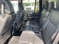 Interior view of a 2006 Land Rover LR3 showcasing black leather seats in the rear passenger area with seat belts and integrated speakers