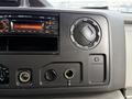 Dashboard of a 2009 Ford Econoline featuring a radio display climate control knobs and auxiliary input ports