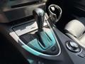 The interior console of a 2004 BMW 6-Series featuring a gear shift lever a circular control knob and leather accents