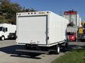 A 2019 Ford E-450 box truck with a plain white cargo area and a ramp at the rear
