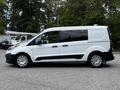 A white 2016 Ford Transit Connect van is parked, featuring a side profile view with black accents and silver wheels