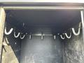 An empty compartment with metal hooks inside a black storage box mounted on a 2016 Ford F-550