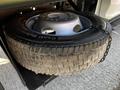 A 2021 Ford F-550 spare tire mounted on a metallic holder with a silver wheel rim visible and the tread of the tire showing signs of wear