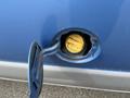 Close-up of the fuel filler cap of a blue 2009 Ford Econoline showing the yellow fuel filler neck inside