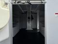 A 2017 Ford Econoline van interior featuring shelves on either side and a central control panel with a phone mounted on the wall