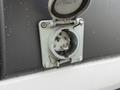 Close-up of a wet charging port cover on a 2017 Ford Transit showing the metal connection inside and the protective flap opened