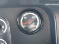 A round air pressure gauge with a red needle pointing slightly above zero and a range marked from 0 to 150