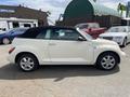 A white 2005 Chrysler PT Cruiser with a black convertible top parked in a lot
