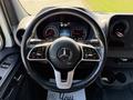 Steering wheel and dashboard of a 2023 Mercedes-Benz Sprinter featuring gauges and a central display