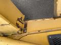 Close-up view of a rusted section of a yellow John Deere 310SJ machine showing the detailed surface of the metal and signs of wear and corrosion