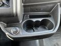 A close-up view of the center console in a 2018 Ford Transit featuring a 12V power outlet and a double cup holder