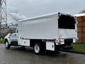 A white 2013 Ford F-650 truck with a large empty cargo box at the back and distinctive taillights