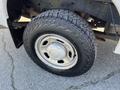 A close-up of a 2013 Ford F-250 SD wheel featuring a rugged tire tread and a silver wheel rim