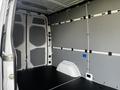 Interior view of a 2022 Mercedes-Benz Sprinter van featuring bare metal walls with reinforcement panels and a black rubber floor