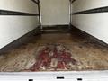 Interior view of the cargo area of a 2019 Hino 195 showing a worn wooden floor with visible stains and marks