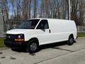 A 2015 Chevrolet Express cargo van in white with a black front grille and chrome accents parked on a street