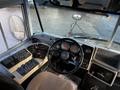 Interior view of a 2005 Blue Bird 48 passenger bus featuring a steering wheel control panel and dashboard with gauges and buttons