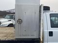 The image shows a 2009 Ford F-450 SD with a shiny metal storage box mounted on the truck bed displaying a circular handle