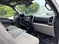 Interior of a 2018 Ford F-150 featuring gray upholstery and a dashboard with touchscreen display and control knobs