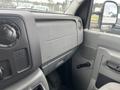The interior dashboard of a 2010 Ford Econoline features a gray control panel with knobs and vents designed for driver accessibility and comfort.