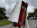 A red and silver 2020 Pottinger Impress machine component with a white covering and visible mechanical parts