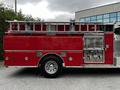 A 1991 Sutphen Deluge fire truck in red with chrome accents and a ladder on top, featuring a side compartment for equipment and large wheels