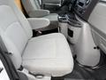 Interior view of a 2022 Ford E-450 showing two light gray fabric seats and a central console with cup holders