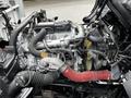Close-up of the engine of a 2014 Hino 195 showing various components including pipes hoses and the engine block with wires connected