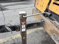A metal lever attached to a support bracket on a piece of heavy machinery with a Bulldog label affixed to it