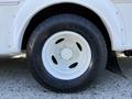 Close-up of a white tire on a 2015 Ford Econoline showcasing a black tread pattern and a white rim