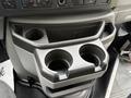 A gray cup holder console with two circular cup holders and a shallow compartment for storage
