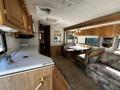 Interior of a 2000 Ford Motorhome featuring a kitchenette with a sink and stove a booth-style dining area and a floral-patterned sofa