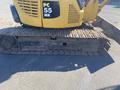A yellow 2006 Komatsu PC55MR2 excavator with a rubber track and a compact design is shown in the foreground