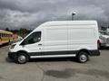 A 2023 Ford Transit cargo van in white with a high roof and side sliding door parked on a concrete surface