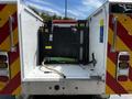 A 2009 Ford F-550 truck with open compartments revealing equipment including a large tank and hoses inside