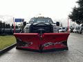 A 2012 Ford F-550 pickup truck with a large red snow plow attached to the front