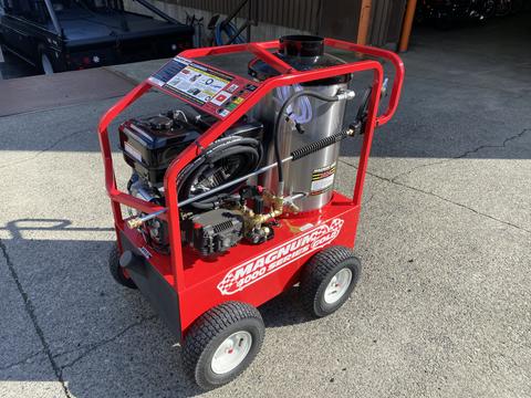 A red 2024 Magnum 4000 Hot Water Pressure Washer with a metal frame and large wheels featuring a control panel and assorted hoses on the side