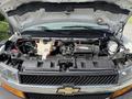 A 2020 Chevrolet Express with its hood open showcasing the engine compartment featuring various components and cables