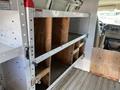 Interior shelving of a 2012 GMC Savana van with wooden compartments for storage and organization