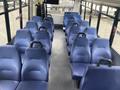 Interior view of a 2018 Chevrolet Express showing rows of blue upholstered seats with armrests and a flat floor