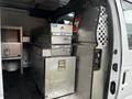 Interior of a 2011 Ford Econoline showing metal storage cabinets and toolboxes organized inside the cargo area